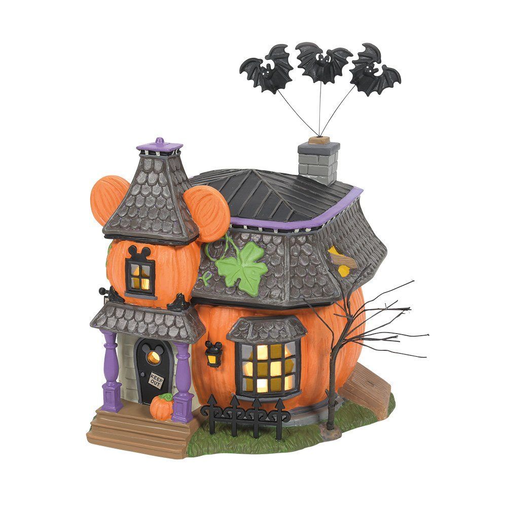 Een Halloweenhuis in de vorm van pompoenen met vleermuizen erboven.