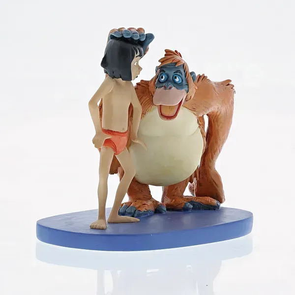 Figuurtje van Mowgli uit The Jungle Book en King Louie, staand op een blauwe ovale sokkel.