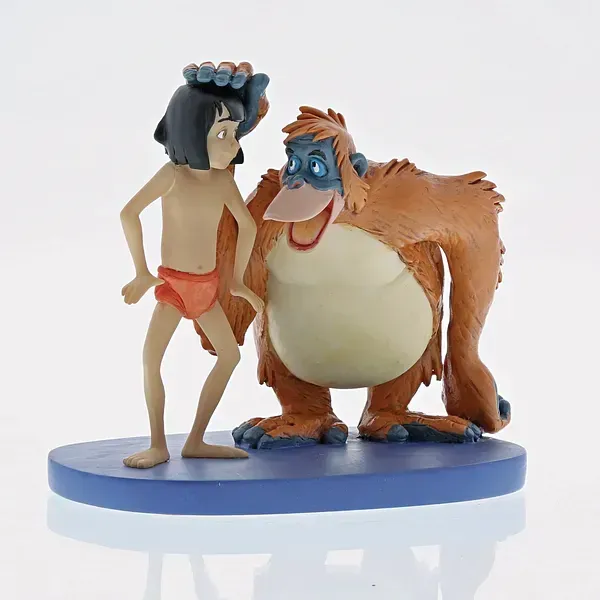 Beeldje van Mowgli en Koning Louie uit The Jungle Book. Mowgli draagt ​​een bloemenkroon; Koning Louie glimlacht.