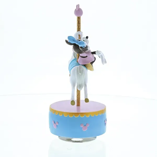 Minnie Mouse op een carrouselpaard bovenop een blauw-roze muziekdoos met Mickey Mouse-pictogrammen.