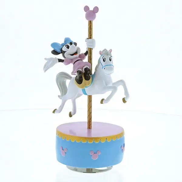 Minnie Mouse rijdt op een wit carrouselpaard, op een muziekdoos met een roze en blauw ontwerp.