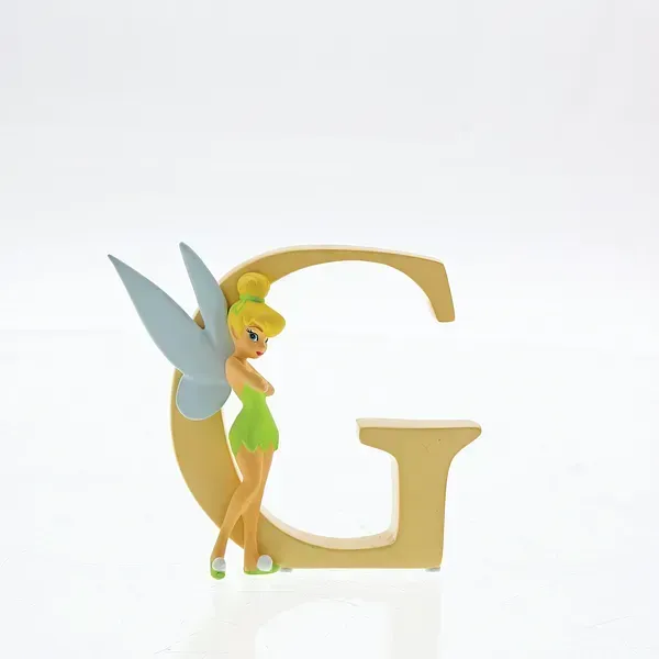 Een Tinkerbell-figuurtje dat tegen een gouden letter 