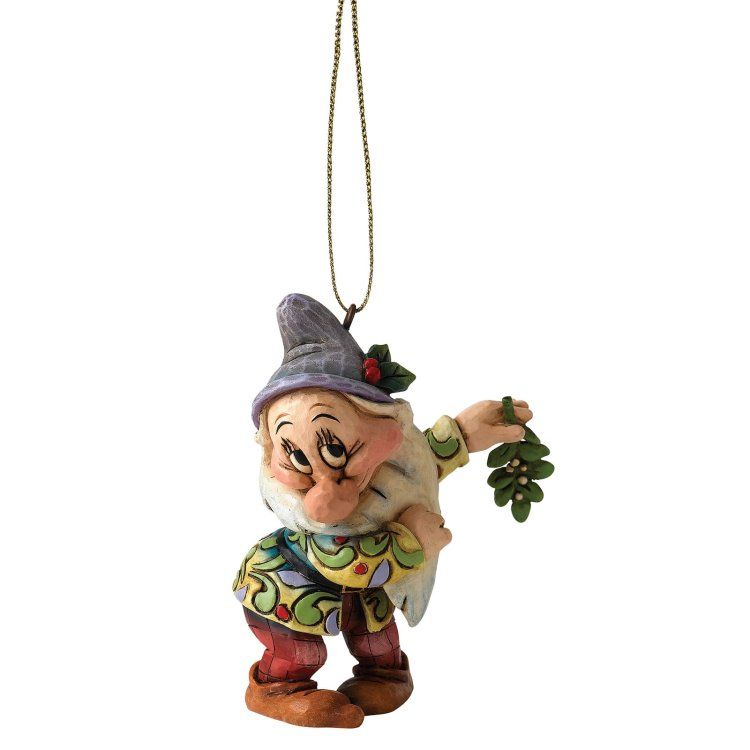 Een sullig figuurtje met een maretak in zijn hand, gekleed in kleurrijke kleren en met een grijze hoed op.
