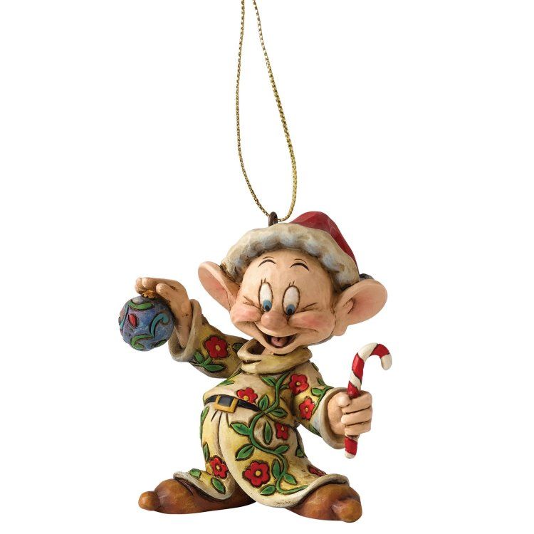 Een sullig kerstornament met een zuurstok en een blauw ornament. Hij draagt ​​een kerstmuts en kleding met een patroon.