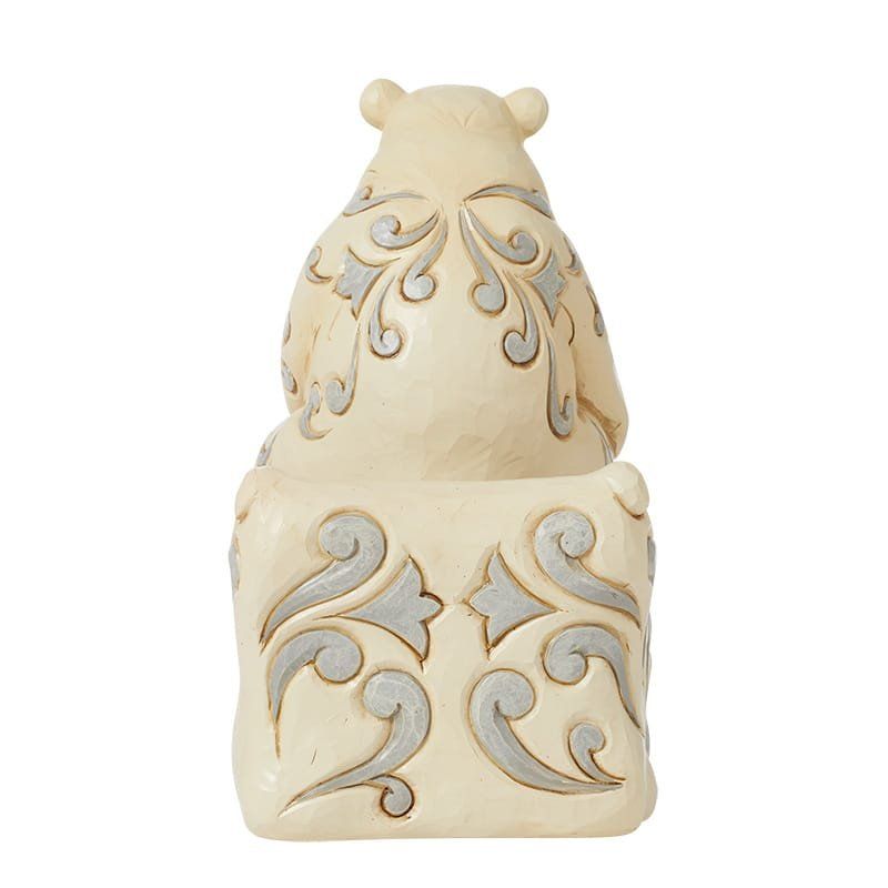 Crèmekleurig berenbeeldje met zilverkleurige krulversiering op de rug en de voet.