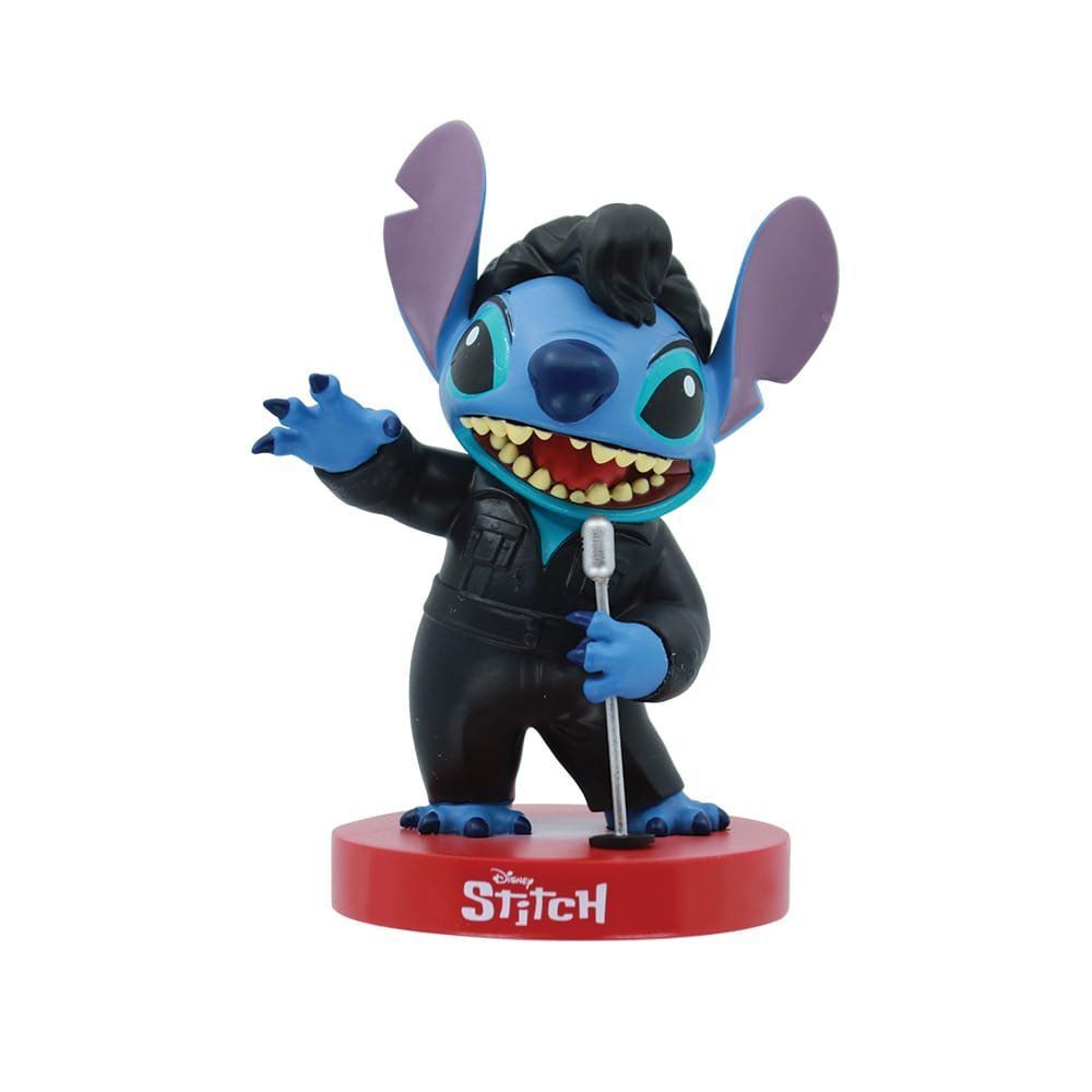 Een Stitch-figuurtje in een outfit geïnspireerd op Elvis Presley, met een microfoon in zijn hand, op een rode sokkel.