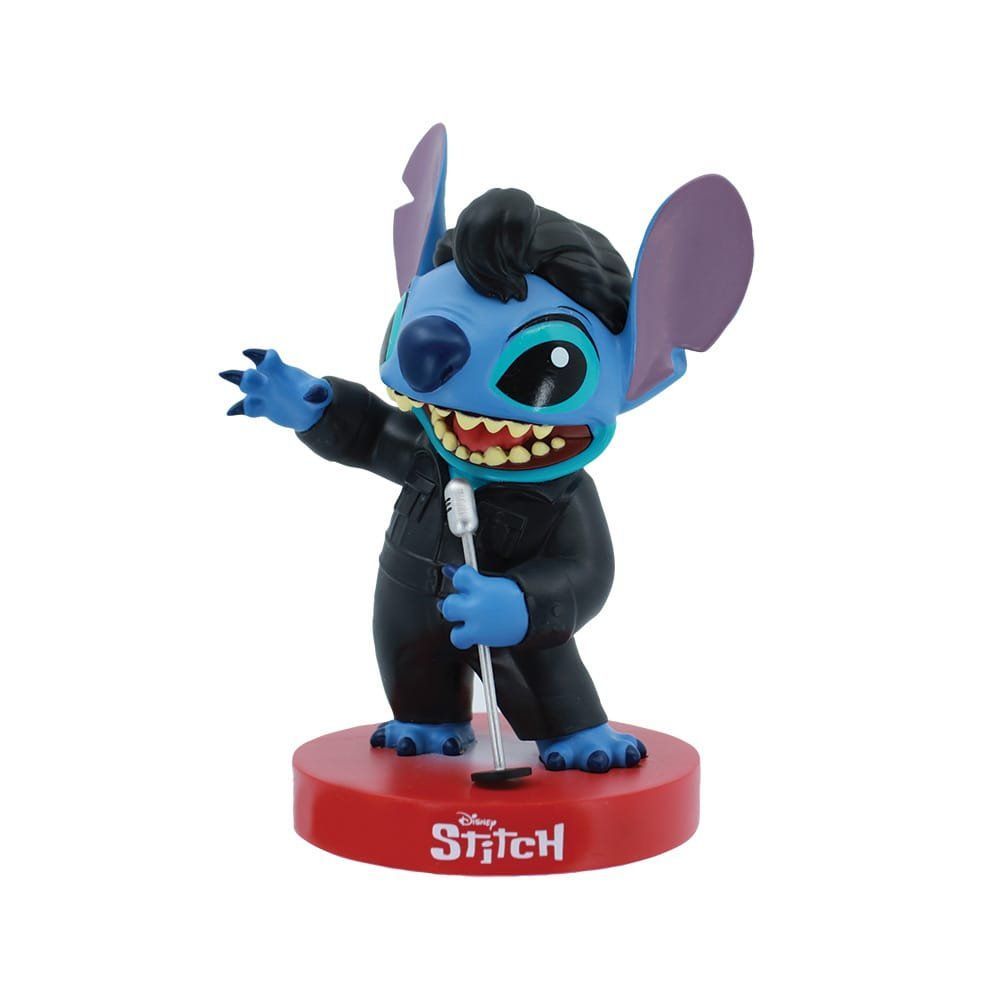 Een Stitch-figuurtje in een outfit geïnspireerd op Elvis Presley, met een microfoon in zijn hand, op een rode sokkel.