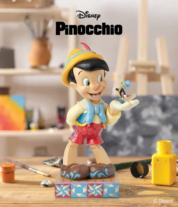 Een Disney Pinokkio-beeldje staat op een houten tafel.