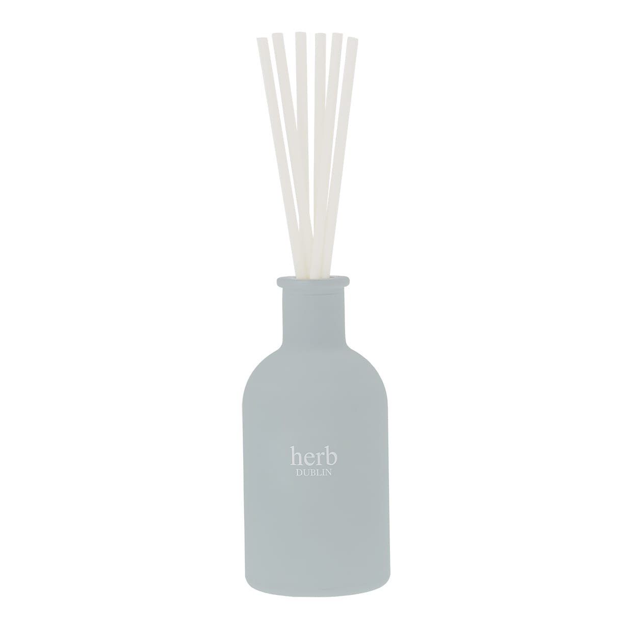 Een lichtblauwe rietdiffuser met witte rietjes en een