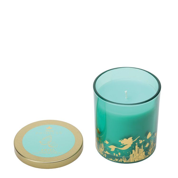 Een turquoise kaars in een glazen pot met gouden accenten, deksel aan de zijkant, witte achtergrond.