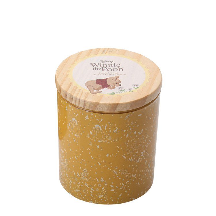 Een Winnie de Pooh-kaars in een gele pot met een houten deksel.