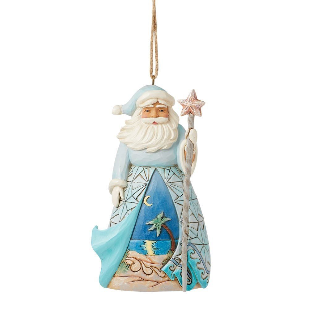 Ornament van de kerstman in blauwe gewaden, met staf, tegen een strandscène.
