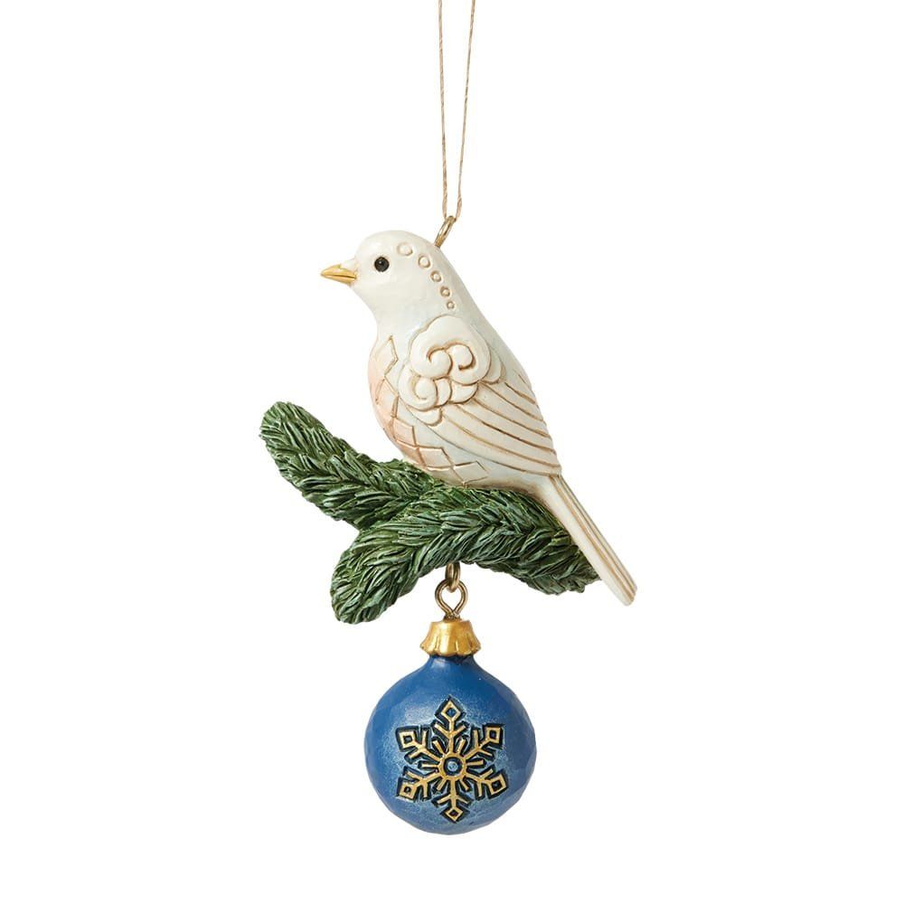 Een witte kerstbal met een vogeltje erop, zittend op een groene tak, een blauwe kerstbal met een gouden sneeuwvlokje.