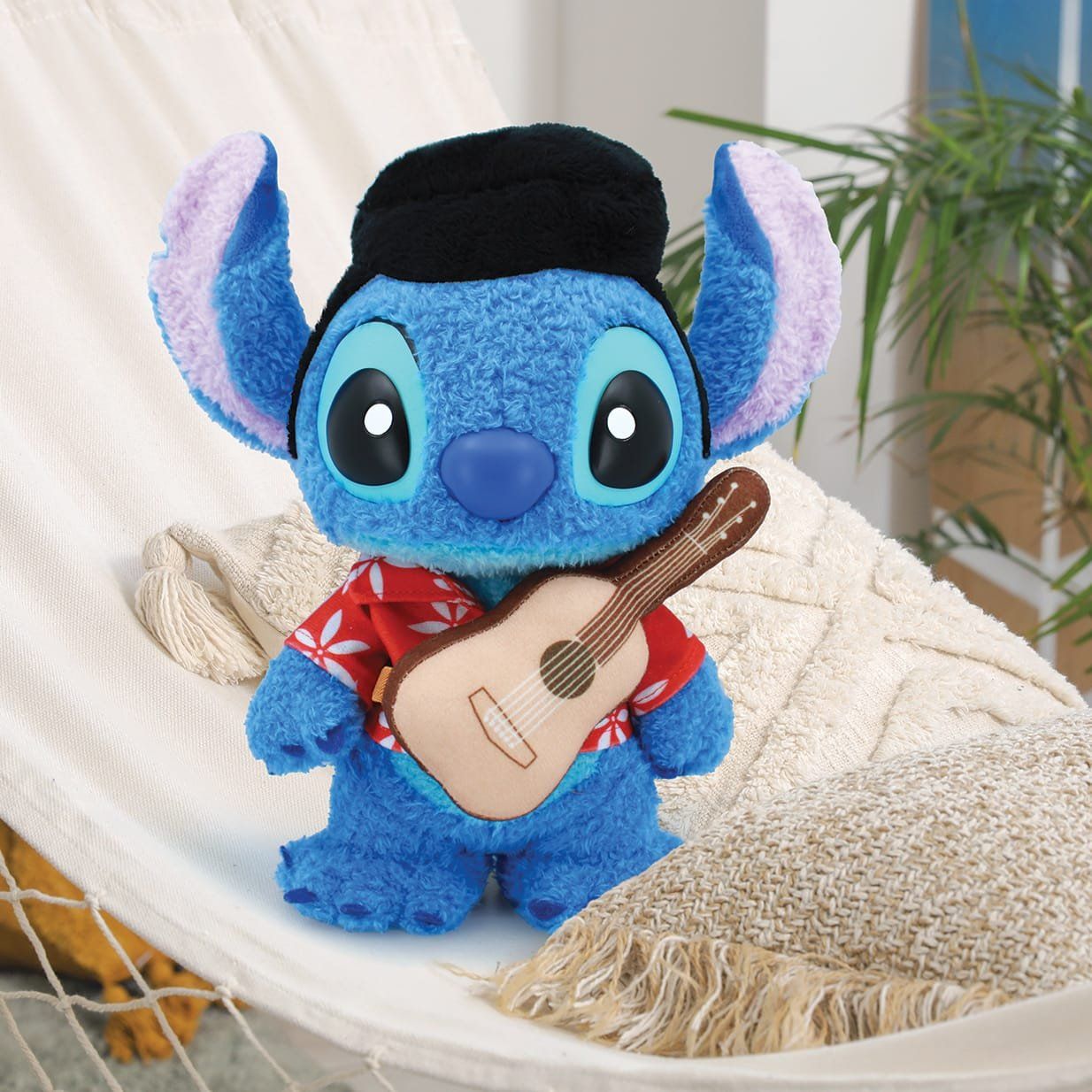 Een pluche Stitch-beestje verkleed als Elvis, met een rood shirt en een ukelele.