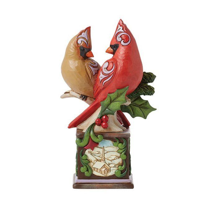 Twee kardinalen op een sokkel. Een rode, een lichtbruine, met decoratieve houtsnijwerken.