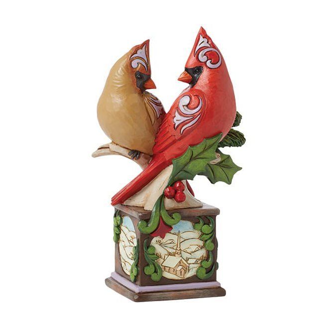 Twee kardinalen op een sokkel. Een rode, een lichtbruine, met decoratieve houtsnijwerken.