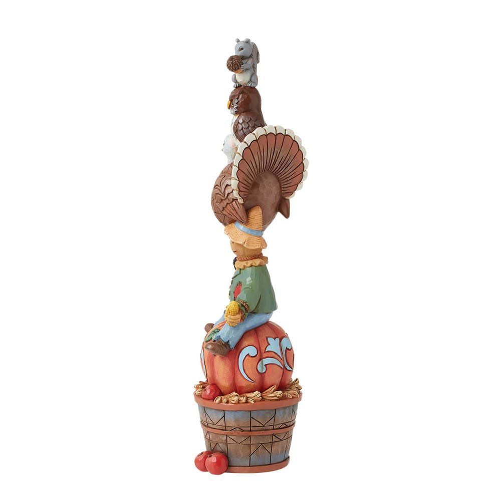 Stapel herfstfiguren: vogelverschrikker, kalkoen, uil, eekhoorn op een pompoen en een mand met appels.