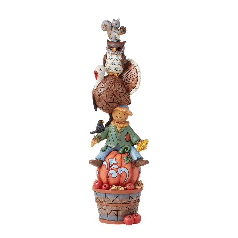 Stapel herfstfiguren: vogelverschrikker, kalkoen, uil, eekhoorn op een pompoen en een mand met appels.