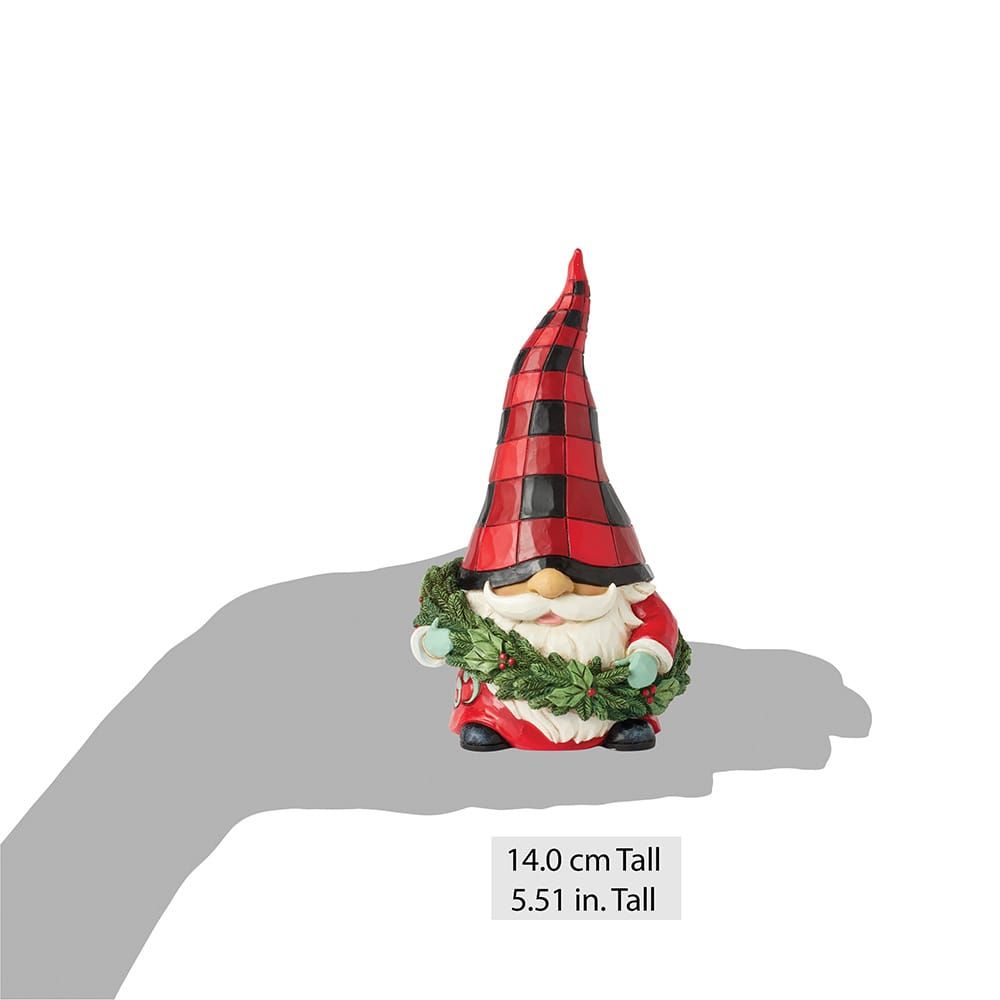 Kerstkabouterfiguurtje met een rood-zwart geruite muts, die een groene krans vasthoudt.