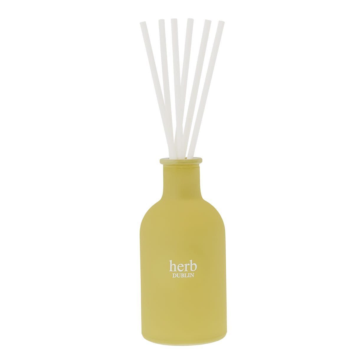 Gele rietdiffuser met witte rietjes en