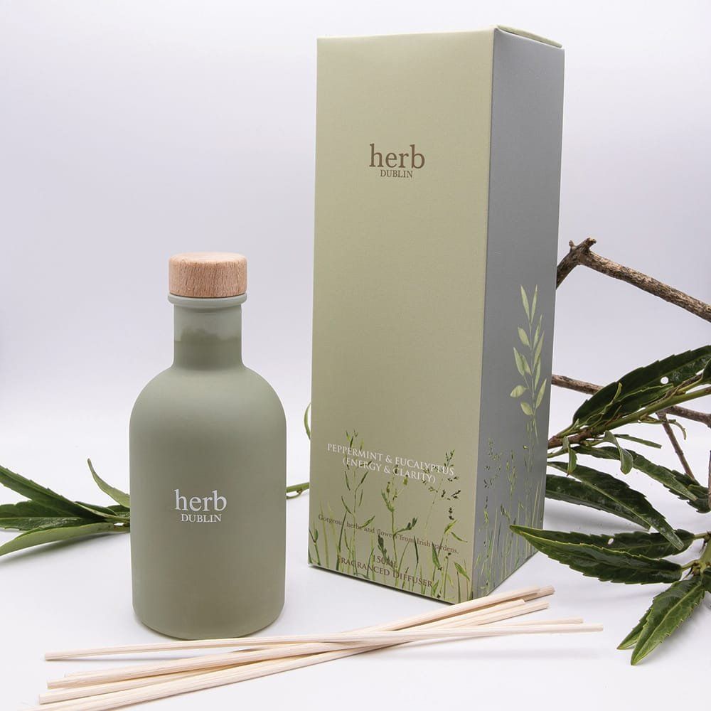 Groene aromatherapie diffuserfles met rietjes, doosje en groen.
