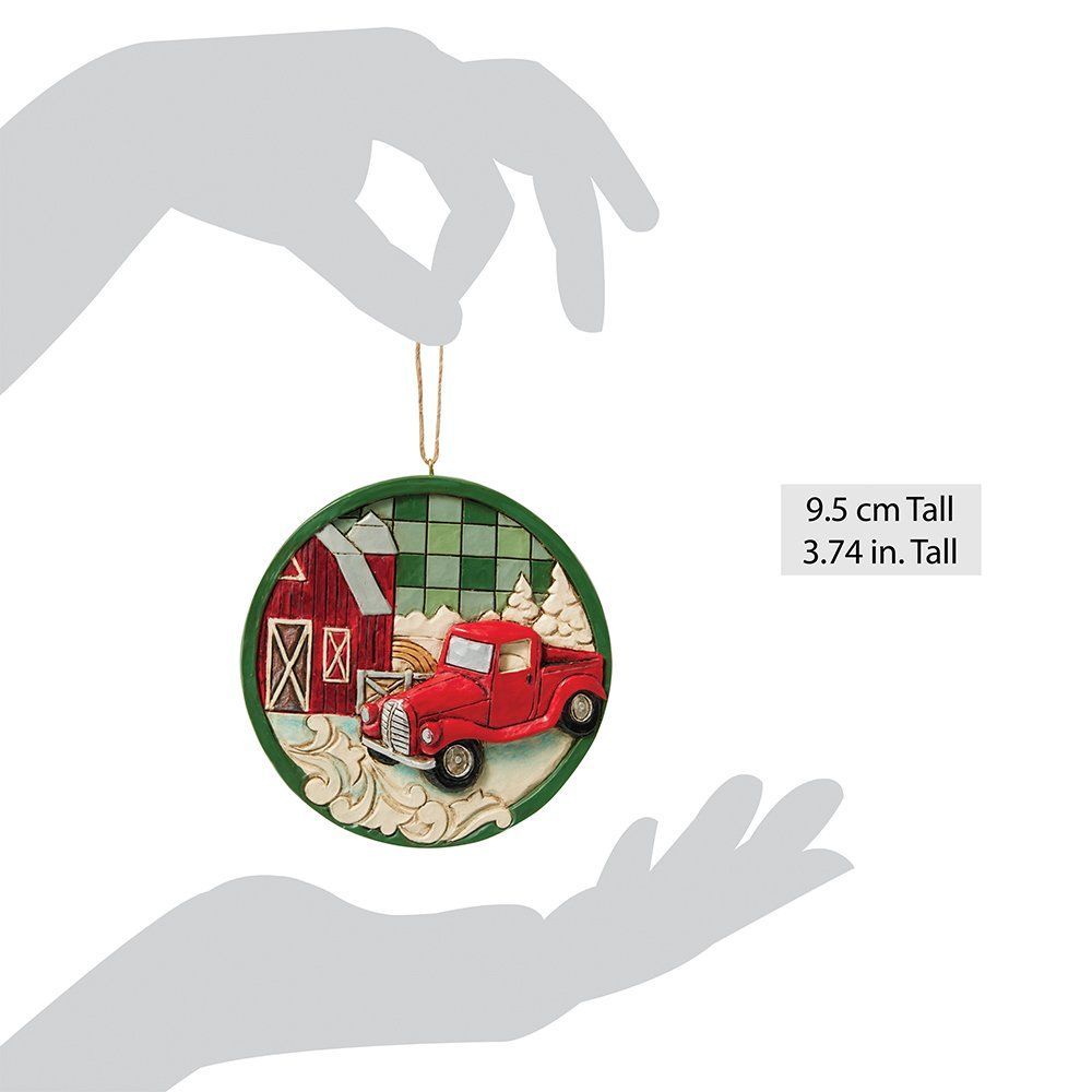 Ornament in de vorm van een rode vrachtwagen met een schuur, bomen en een groene achtergrond.