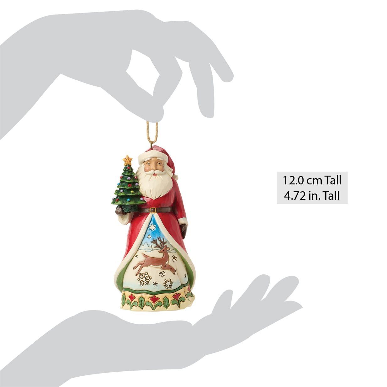 Een kerstornament van de Kerstman die een kerstboom vasthoudt, gekleed in een rode jas met een tafereel van rendieren, hangend aan een touwtje.