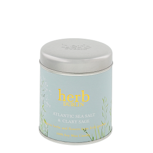 Klein, rond, lichtblauw metalen blikje van Herb Dublin Atlantic Sea Salt & Clary Sage. Grijs deksel, gouden letters.