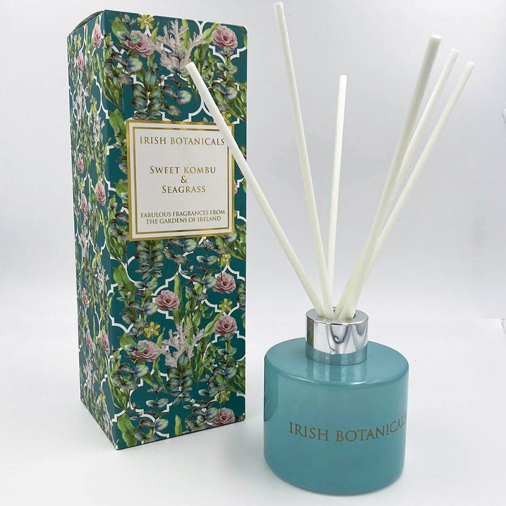 Turquoise rietdiffuser en doosje met patroon. Witte rietjes, turquoise glazen fles, doosje met bloemenprint, etiket: