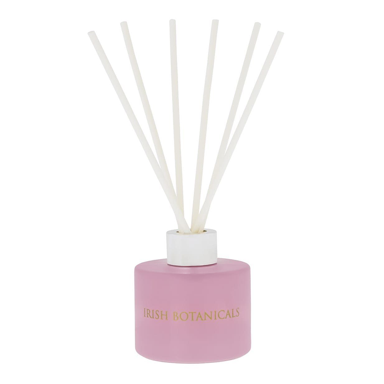 Roze etherische olie diffuser met witte rietjes.