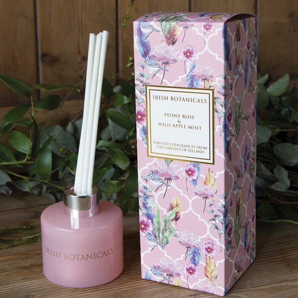 Roze geurdiffuser met rietjes en bijpassende doos met bloemenpatroon.