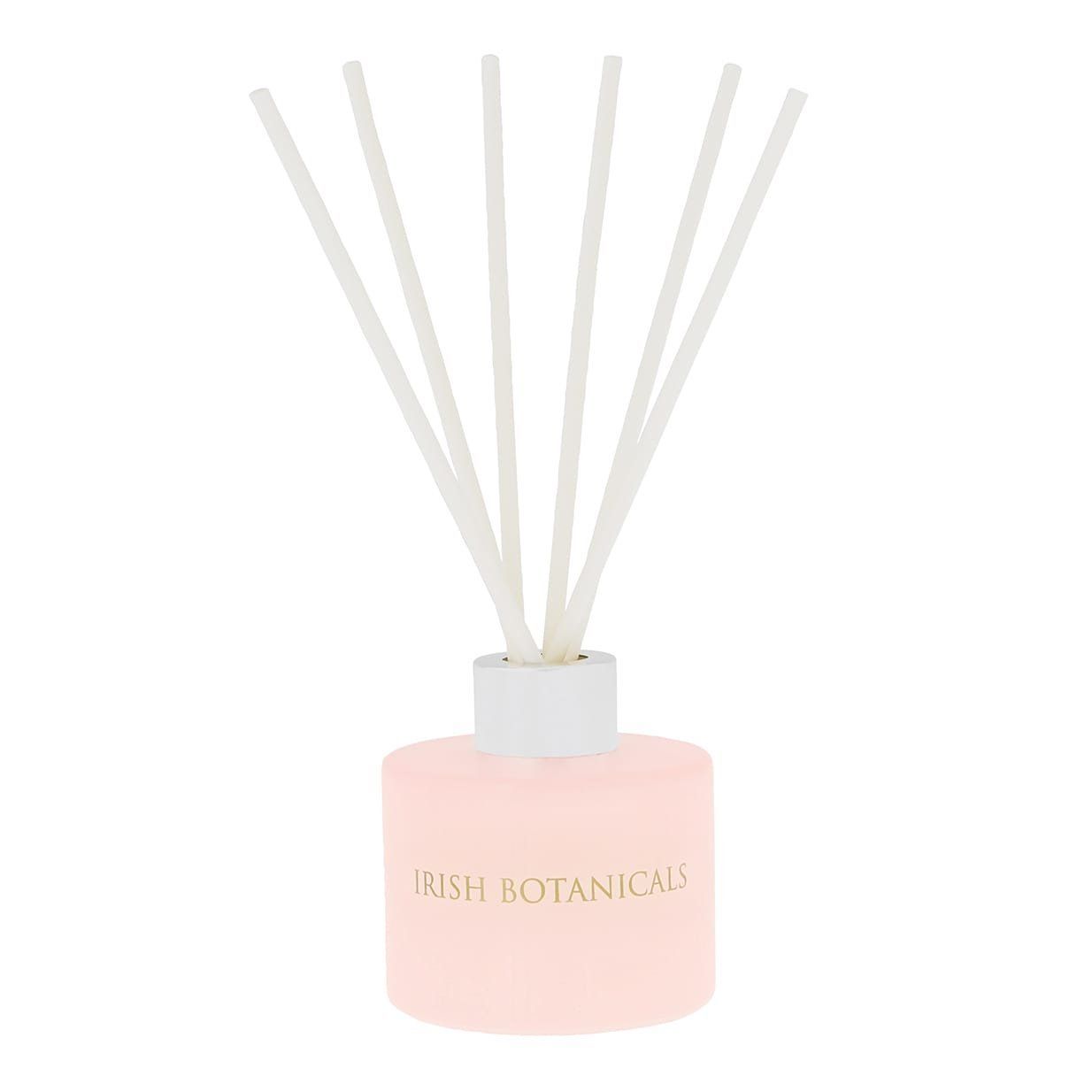 Roze etherische olie diffuser met witte rietjes; gouden letters: IRISI BOTANICS.