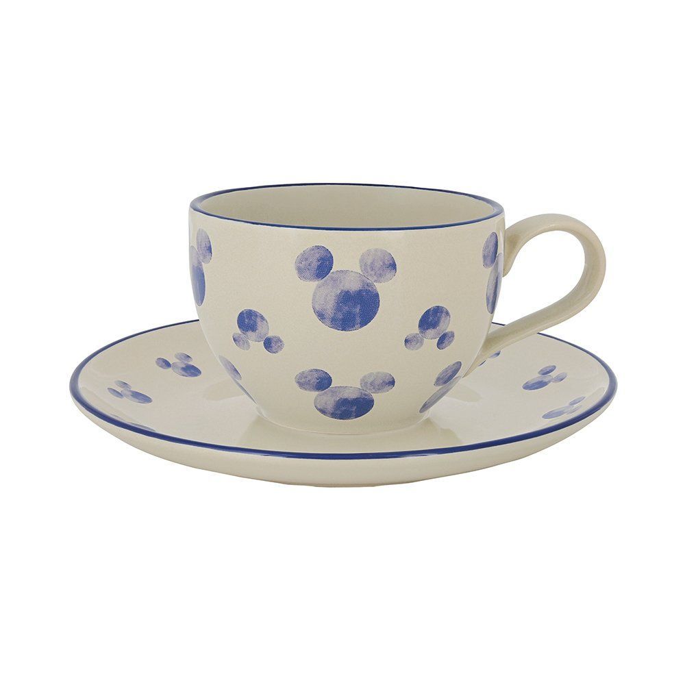 Crèmekleurig theekopje en schoteltje met blauwe Mickey Mouse-silhouetten en rand.