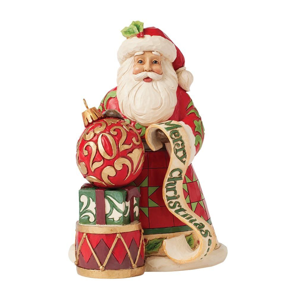 Een kerstmanfiguur met een kerstbal, cadeautjes en een rol met de tekst