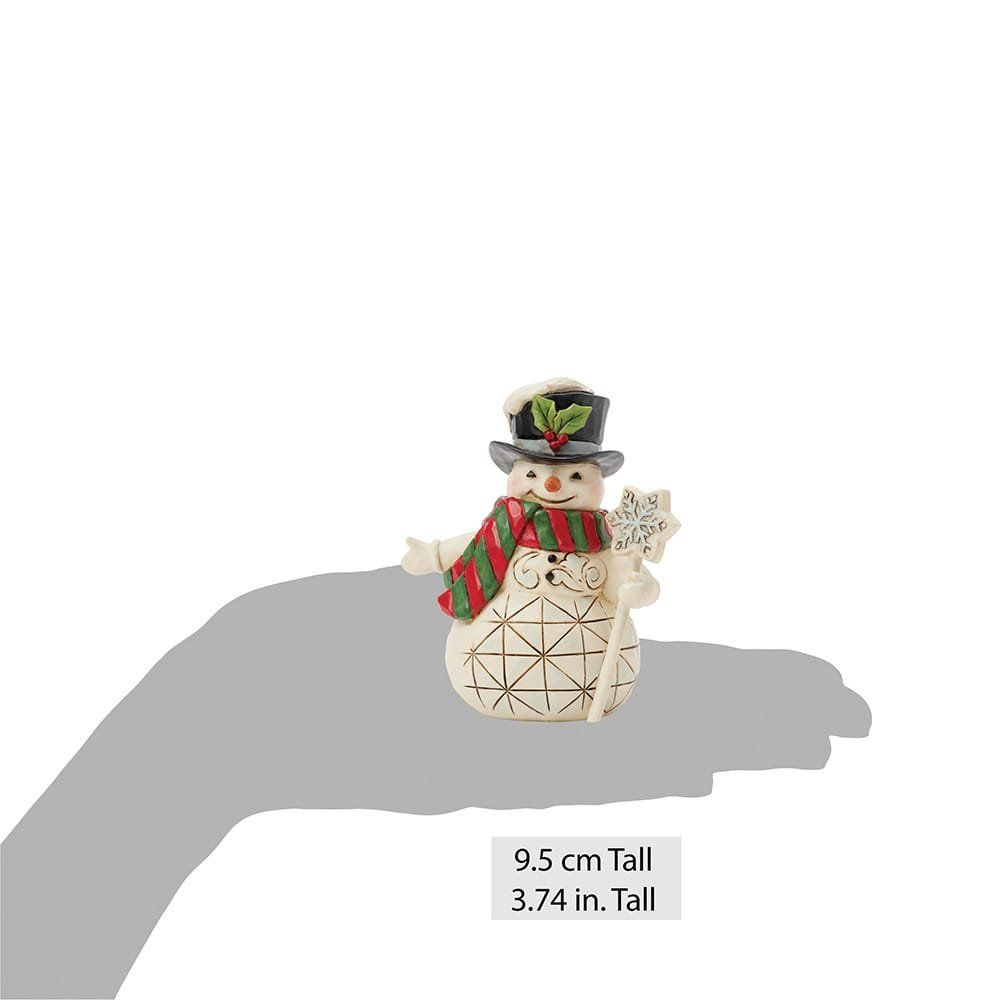 Een sneeuwpopfiguurtje met een hoge hoed, een sneeuwvlokkenstokje in zijn hand en een sjaal om.