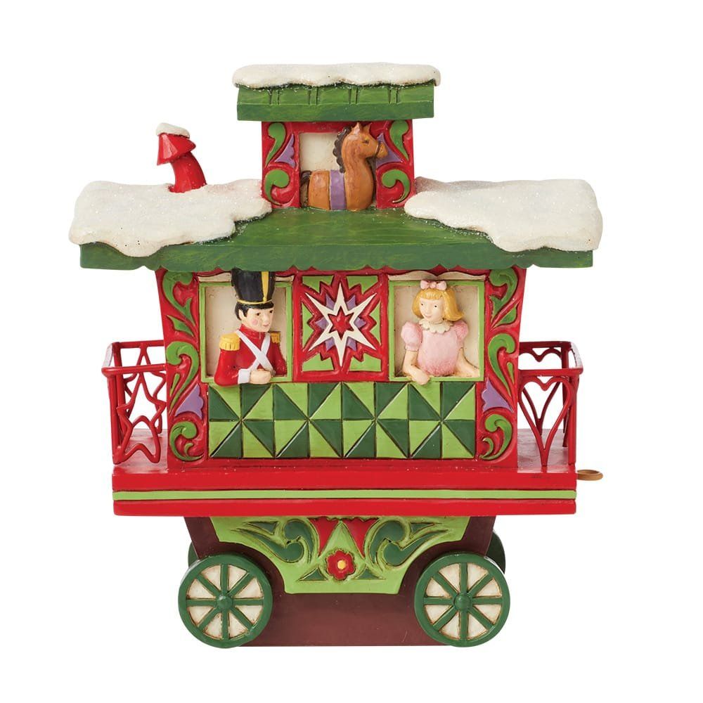 Feestelijk speelgoedtreintje met een soldaat, een meisje en een paard erin, versierd in rood en groen met sneeuw.