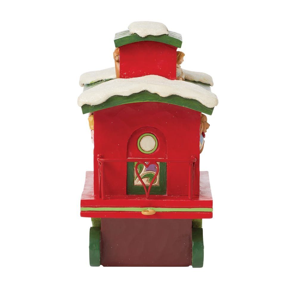 Rode kersttreinwagon met sneeuw, groene accenten en een raam.