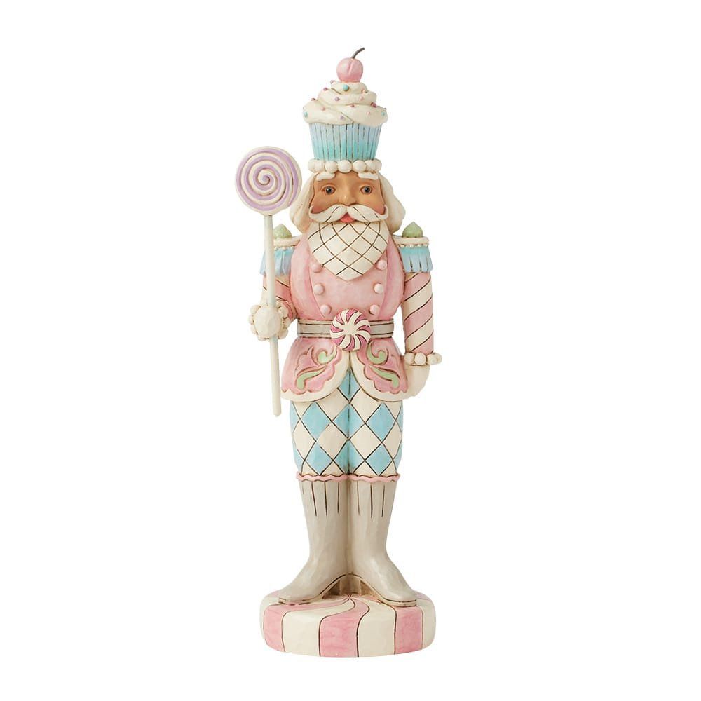 Een roze en blauwe notenkraker met een lolly, waarop een cupcake en een kers staan.