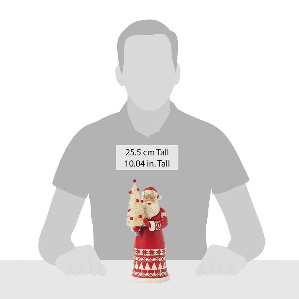 Een kerstmanfiguur in een rode jas met een wit patroon op de zoom, die een klein kerstboompje vasthoudt.