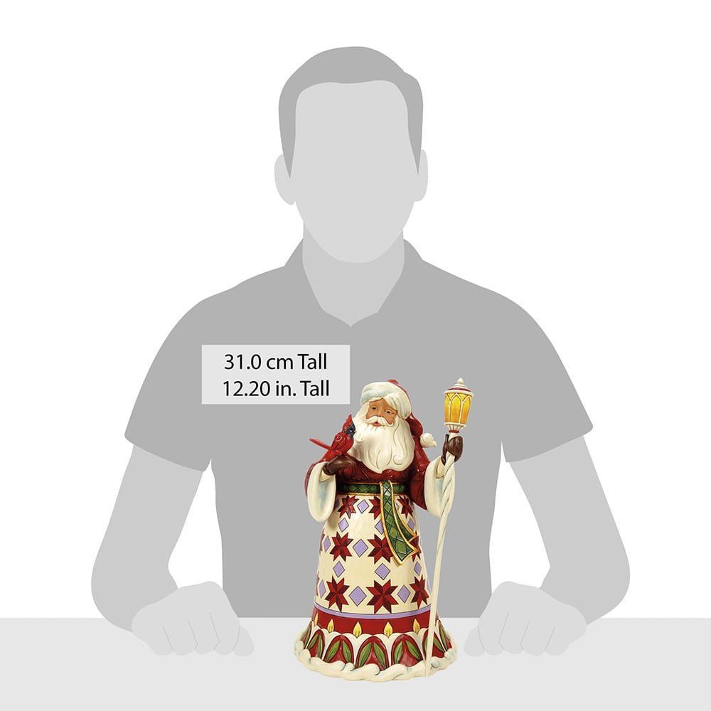 Feestelijk kerstmanfiguurtje, in rode jas, met een lantaarn en een kardinaal.