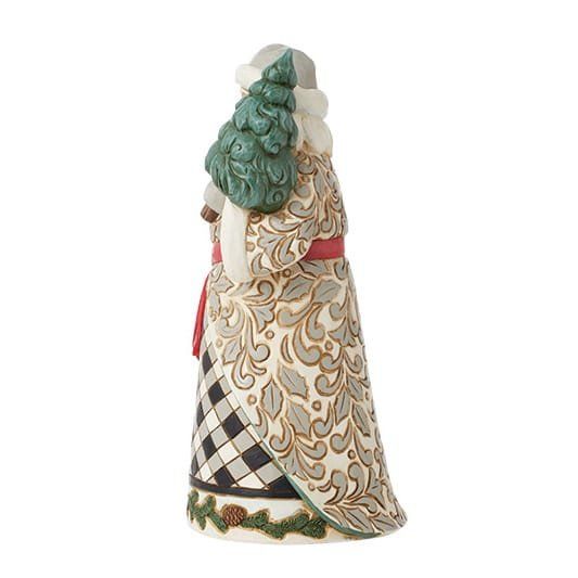 Een kerstmanfiguur met een kerstboom in zijn handen, gekleed in een jas met patroon, een rode sjerp en een grijze muts.