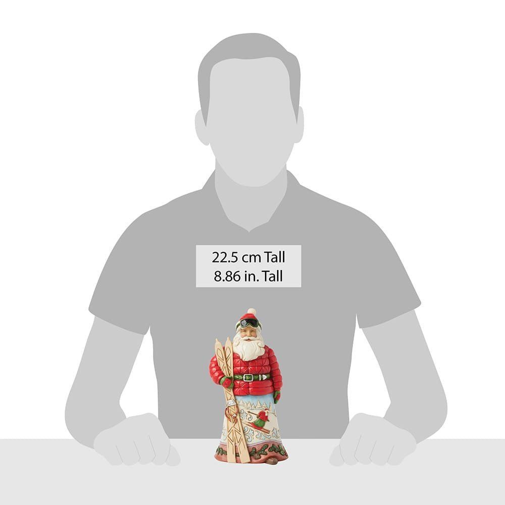 Skiënde kerstmanfiguur in rode gewatteerde jas, met ski's en skibril; rok beschilderd met een winterlandschap.