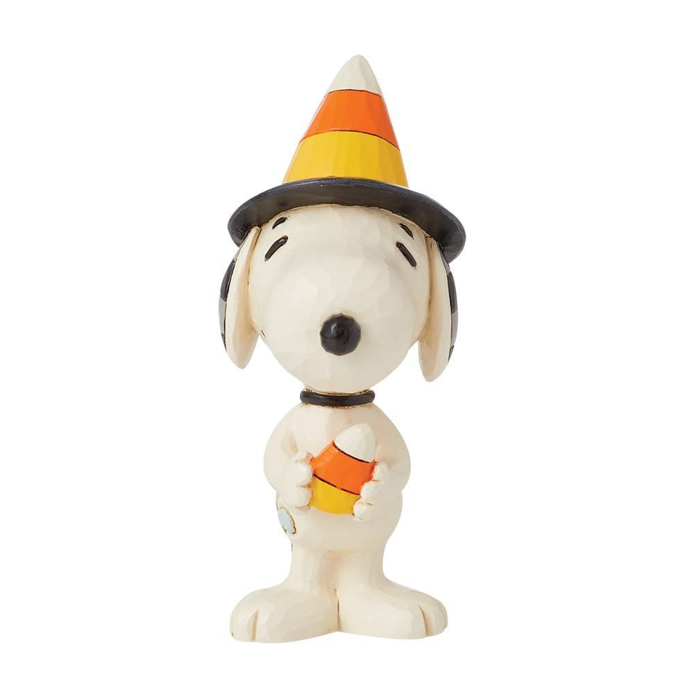 Een Snoopy-figuurtje met een snoepmaïshoed op, die een snoepmaïs vasthoudt.