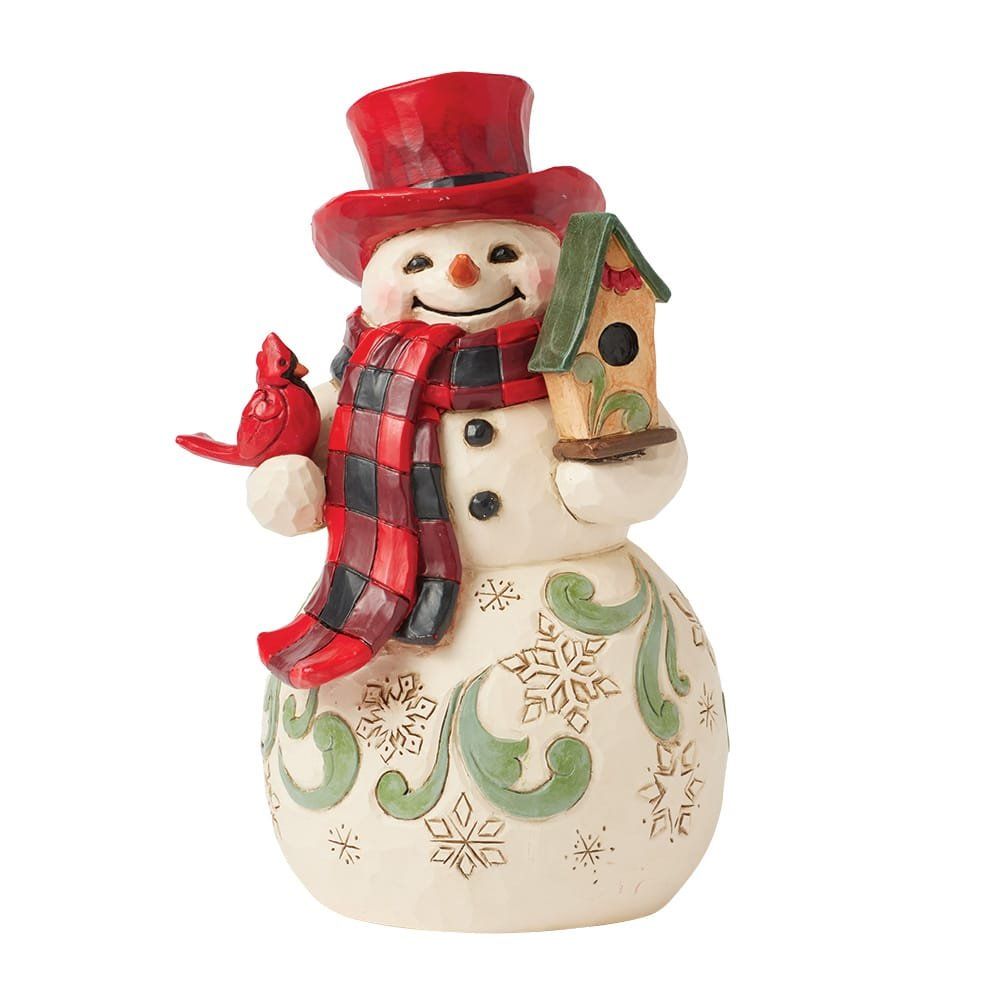 Een sneeuwpopfiguur met een rode hoge hoed en sjaal, die een vogelhuisje en een rode kardinaal vasthoudt.