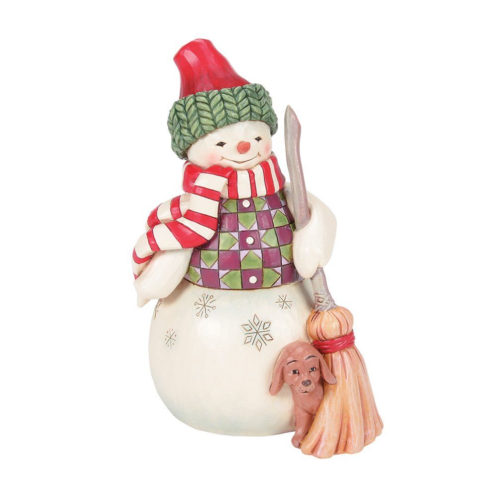 Een sneeuwpopfiguurtje met een rode muts, een sjaal en een hond ernaast.