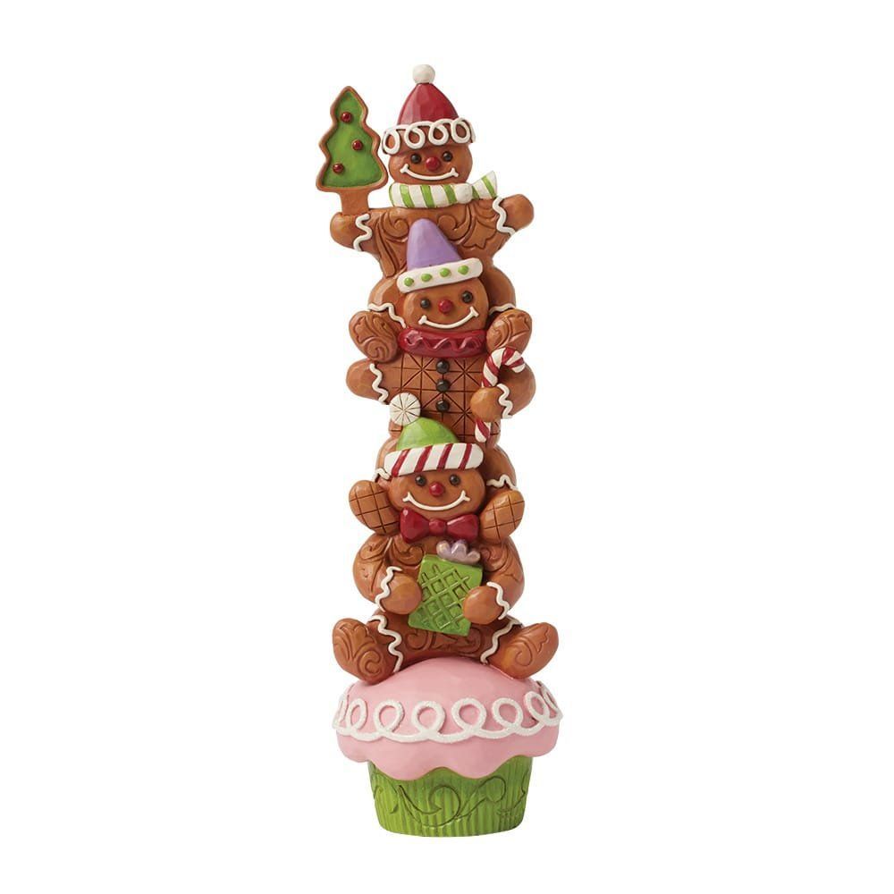 Peperkoekmannetjes opgestapeld op een cupcake, met cadeautjes in hun handen en hoedjes op.
