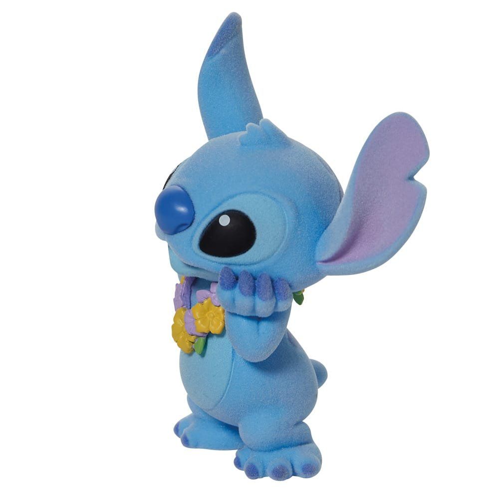 Een Stitch-figuurtje, blauw met grote oren, met een bloemenkrans om zijn nek, kijkt opzij en houdt zijn handen voor zijn gezicht.