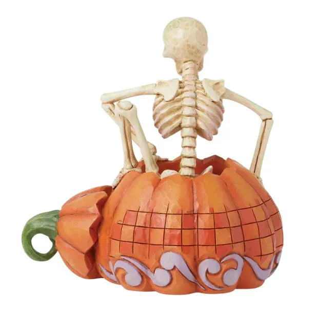 Een skeletfiguur die uit een uitgeholde pompoen tevoorschijn komt; oranje en beige kleuren; Halloweenversiering.