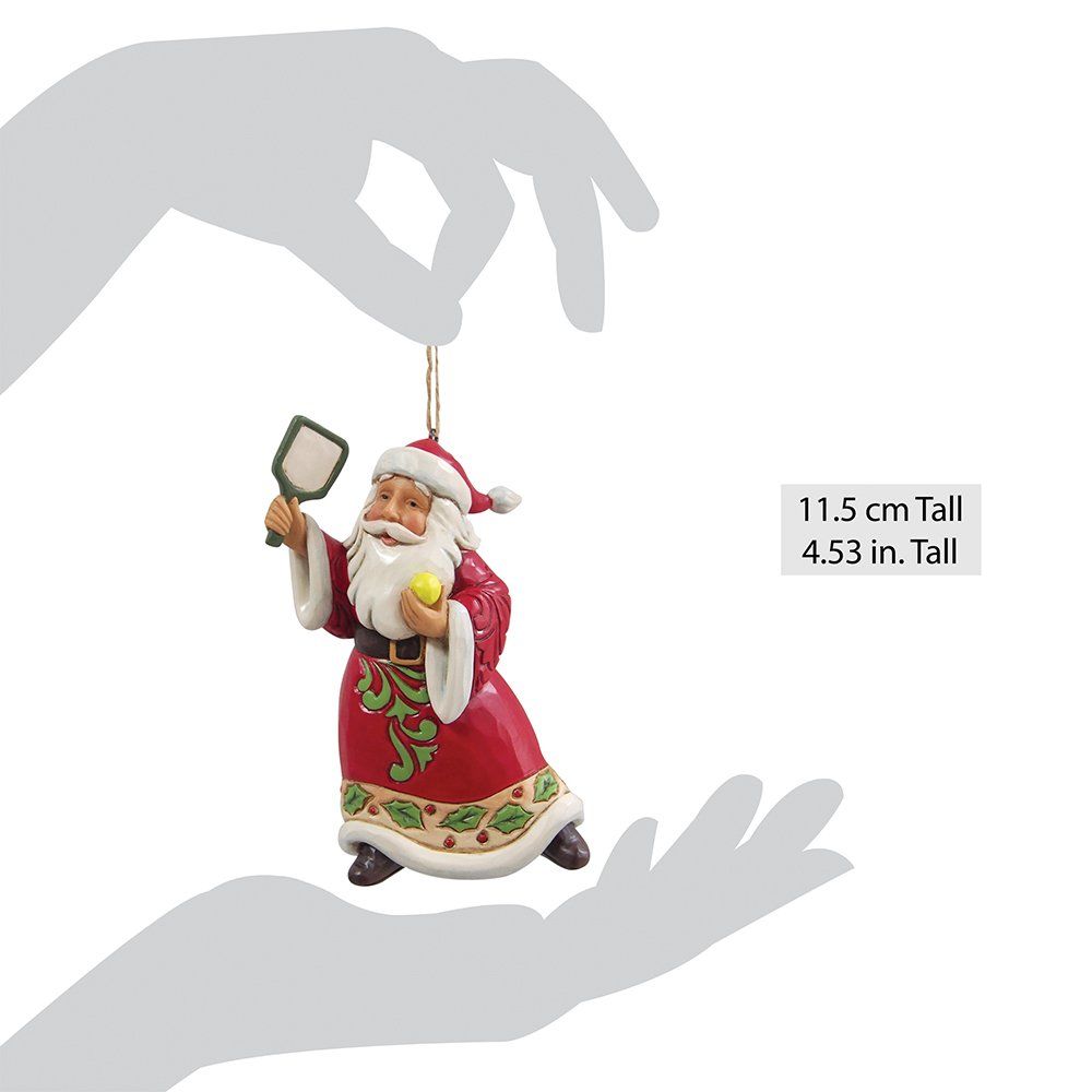 Een kerstmanfiguur met een gele bal en een peddel, gekleed in een rood pak met groene accenten.