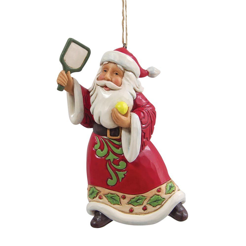 Een kerstmanfiguur met een gele bal en een peddel, gekleed in een rood pak met groene accenten.